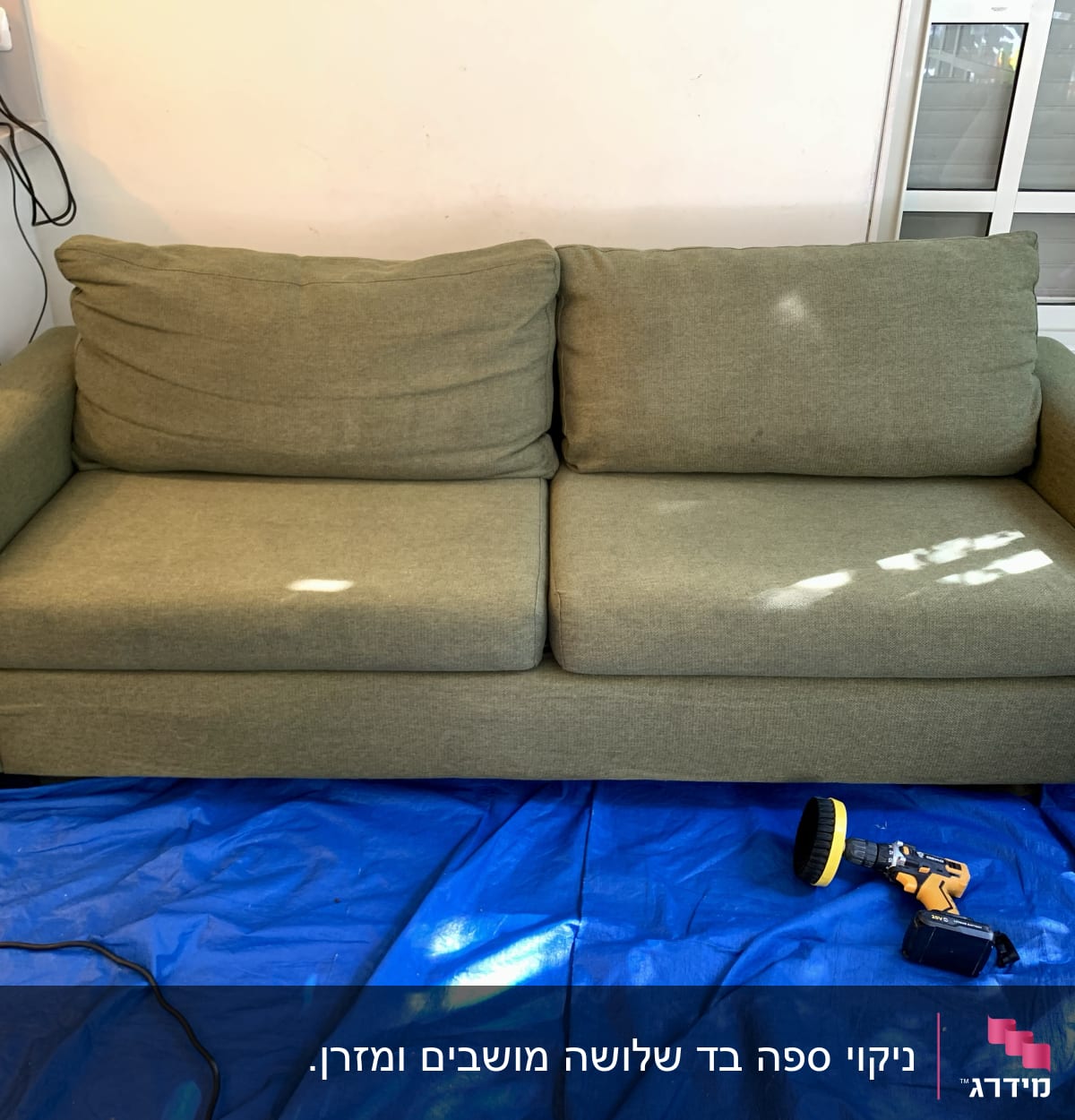 ספה ירוקה עם מכונת ניקוי על יריעת פלסטיק כחולה